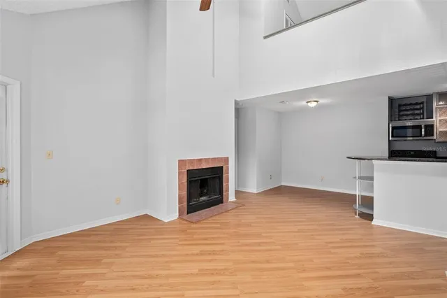 a view of empty room with wooden floor and fireplace