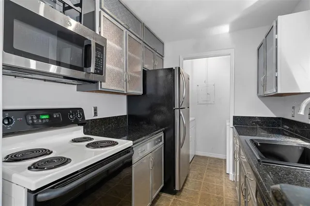 a kitchen with stainless steel appliances granite countertop a stove microwave and refrigerator