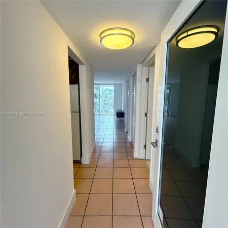 a view of a hallway with wooden floor and a chandelier