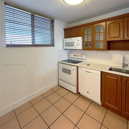a kitchen with a stove a sink and cabinets
