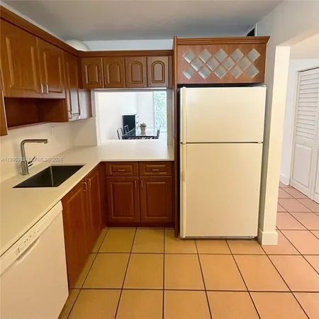 a kitchen with a sink a refrigerator and cabinets