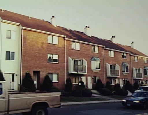 a front view of a building with lot of cars parked