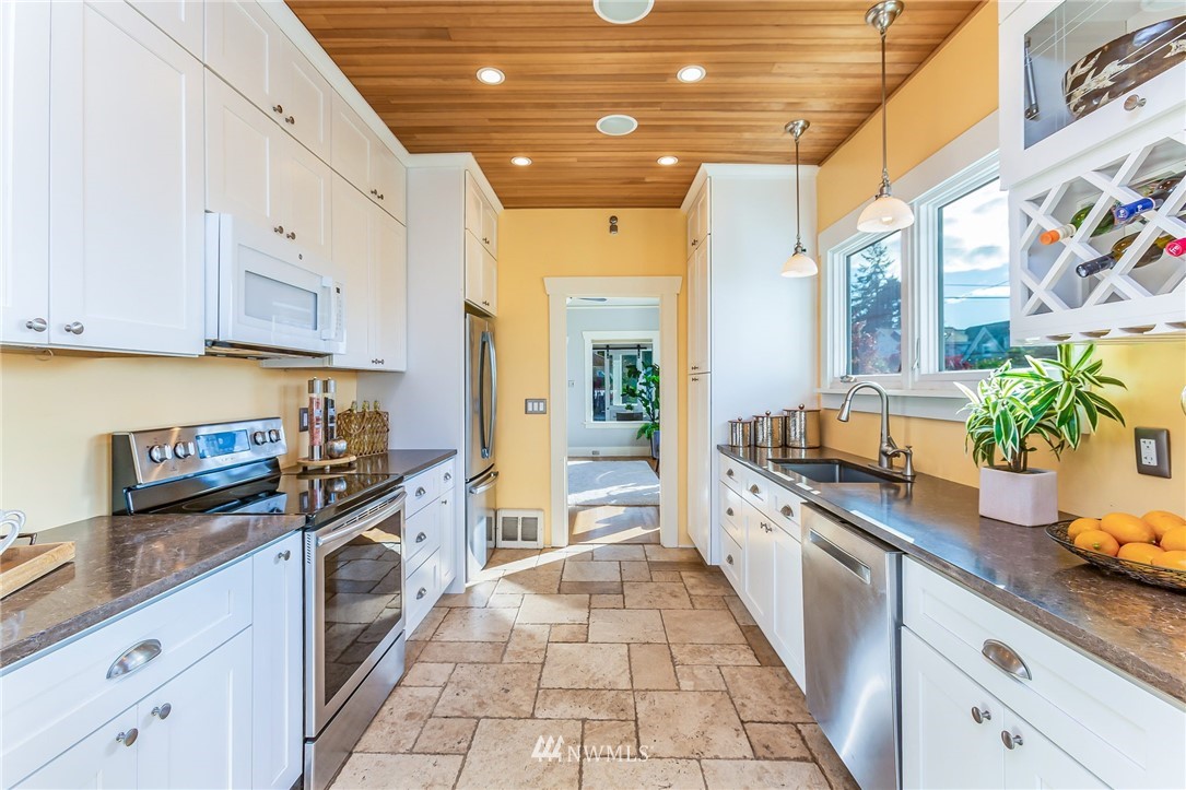 4140 Southwest Ida Street Seattle, WA 98136 - Photo 13 of 39 a kitchen with granite countertop a stove a sink and cabinets