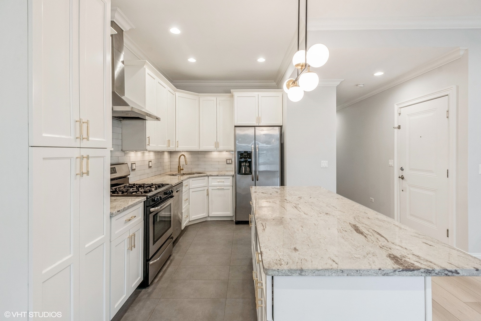 1041 West Madison Street, Unit 3 Chicago, IL 60607 - Photo 2 of 15 a kitchen with kitchen island a stove a sink a refrigerator and white cabinets with wooden floor