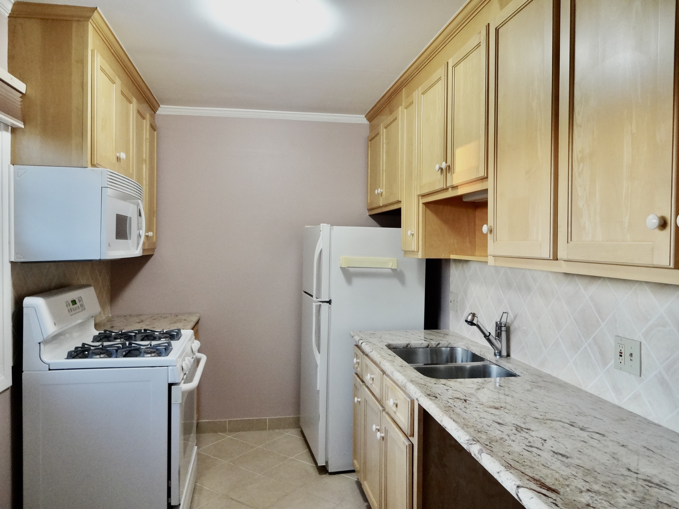 245 Unquowa Road, Unit 34 Fairfield, CT 06824 - Photo 8 of 24 a kitchen with a sink stove and cabinets
