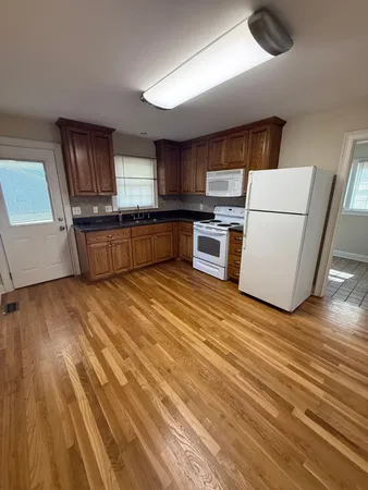 a kitchen with stainless steel appliances wooden floors and wooden cabinets