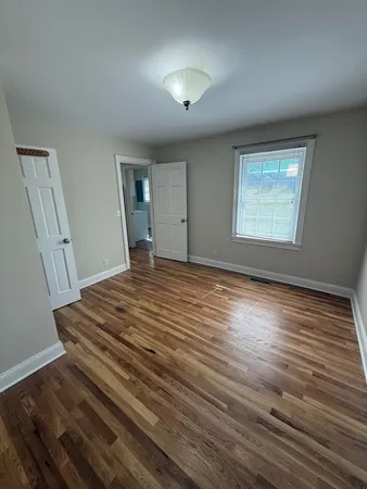 a view of a room with wooden floor and window
