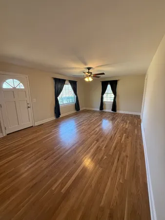 a view of empty room with wooden floor