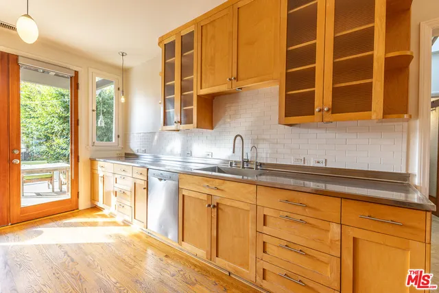 a kitchen with stainless steel appliances granite countertop a refrigerator a stove and a sink