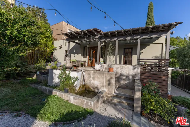 a view of a street with potted plants and large trees