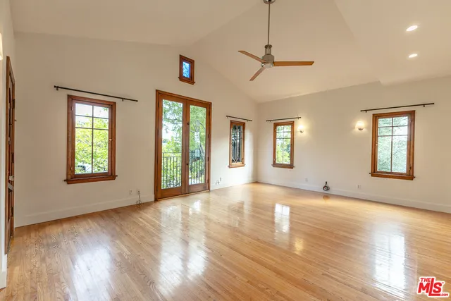 a view of an empty room with glass door and windows