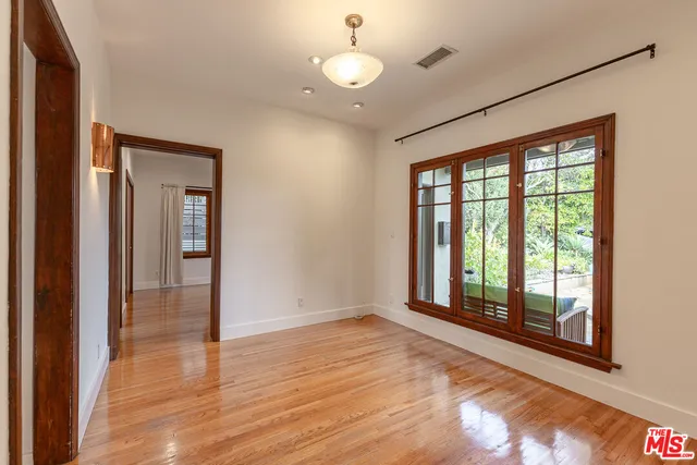 a kitchen with stainless steel appliances granite countertop a stove a sink and white cabinets next to a window