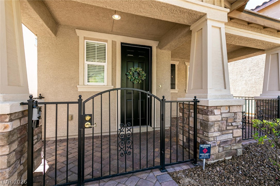 3045 Camino Rico Avenue Henderson, NV 89044 - Photo 5 of 44 Property entrance featuring a gate, stucco siding, and a porch