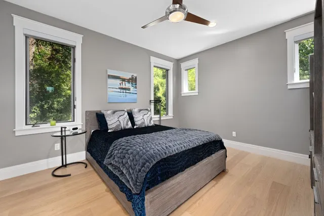 a spacious bathroom with a granite countertop sink a toilet a mirror and shower