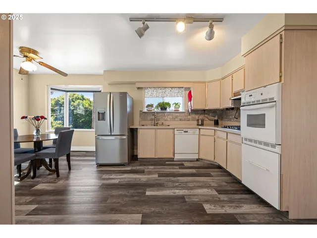 a kitchen with stainless steel appliances a sink cabinets and wooden floor