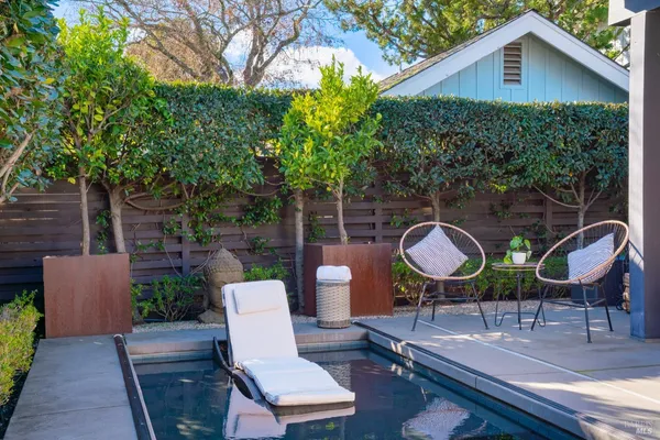 a view of a chairs and table in backyard