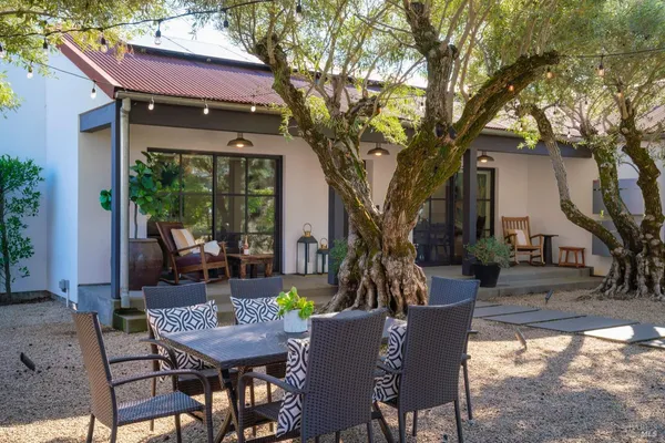 a view of a house with backyard and sitting area
