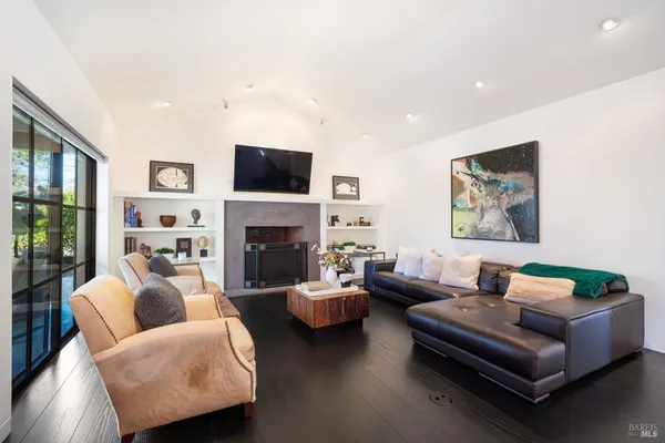 a living room with furniture a flat screen tv and a fireplace