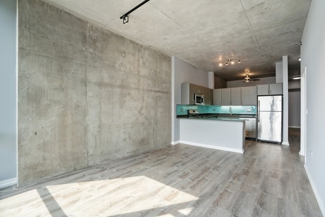 235 West Van Buren Street, Unit 1505 Chicago, IL 60607 - Photo 11 of 28 a large kitchen with white cabinets and wooden floor