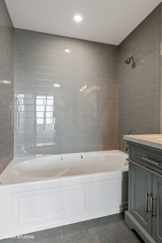 235 West Van Buren Street, Unit 1505 Chicago, IL 60607 - Photo 19 of 28 a bathroom with a bathtub and a shower