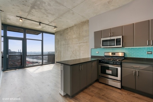 235 West Van Buren Street, Unit 1505 Chicago, IL 60607 - Photo 10 of 28 a kitchen with stainless steel appliances granite countertop a stove and a microwave