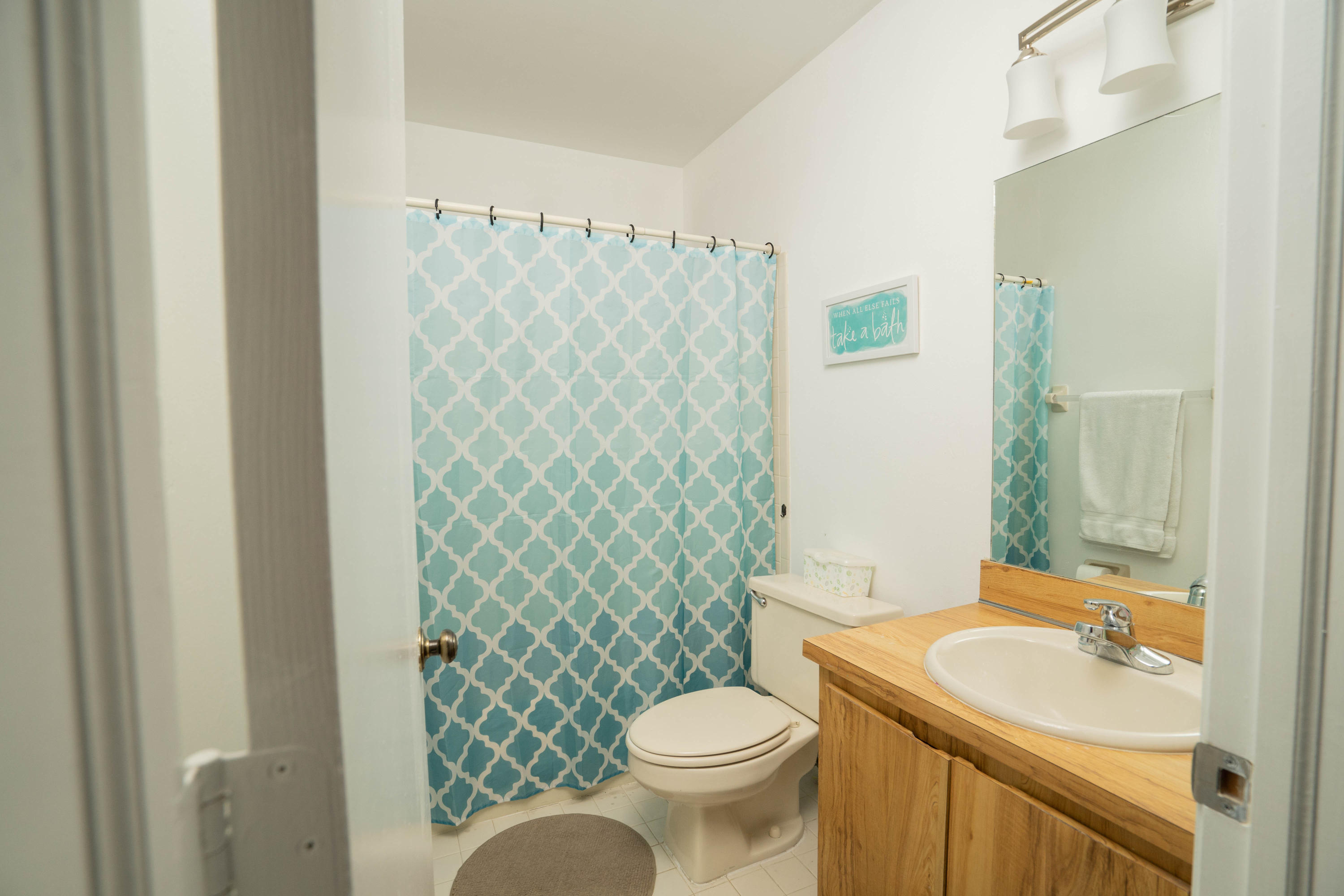 8930 Southwest 19th Street, Unit G Boca Raton, FL 33433 - Photo 12 of 18 a bathroom with a sink a toilet and shower curtain