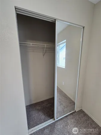 a view of a big room with windows and chandelier fan