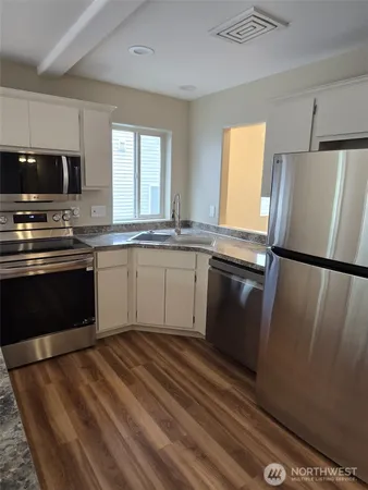 an empty room with a chandelier fan and windows