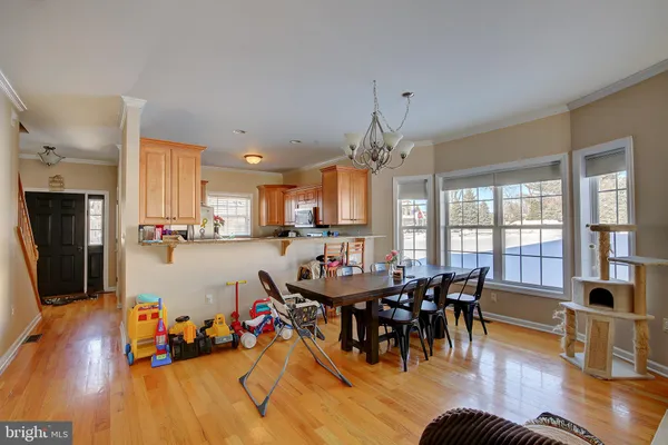 a view of a dining room with furniture a chandelier and wooden floor