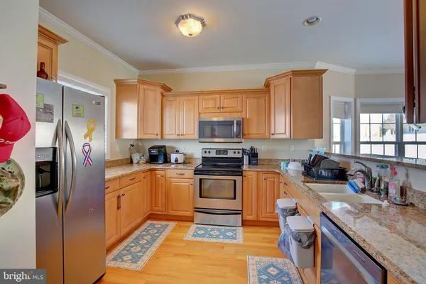a kitchen with stainless steel appliances granite countertop a refrigerator a stove top oven a sink and dishwasher