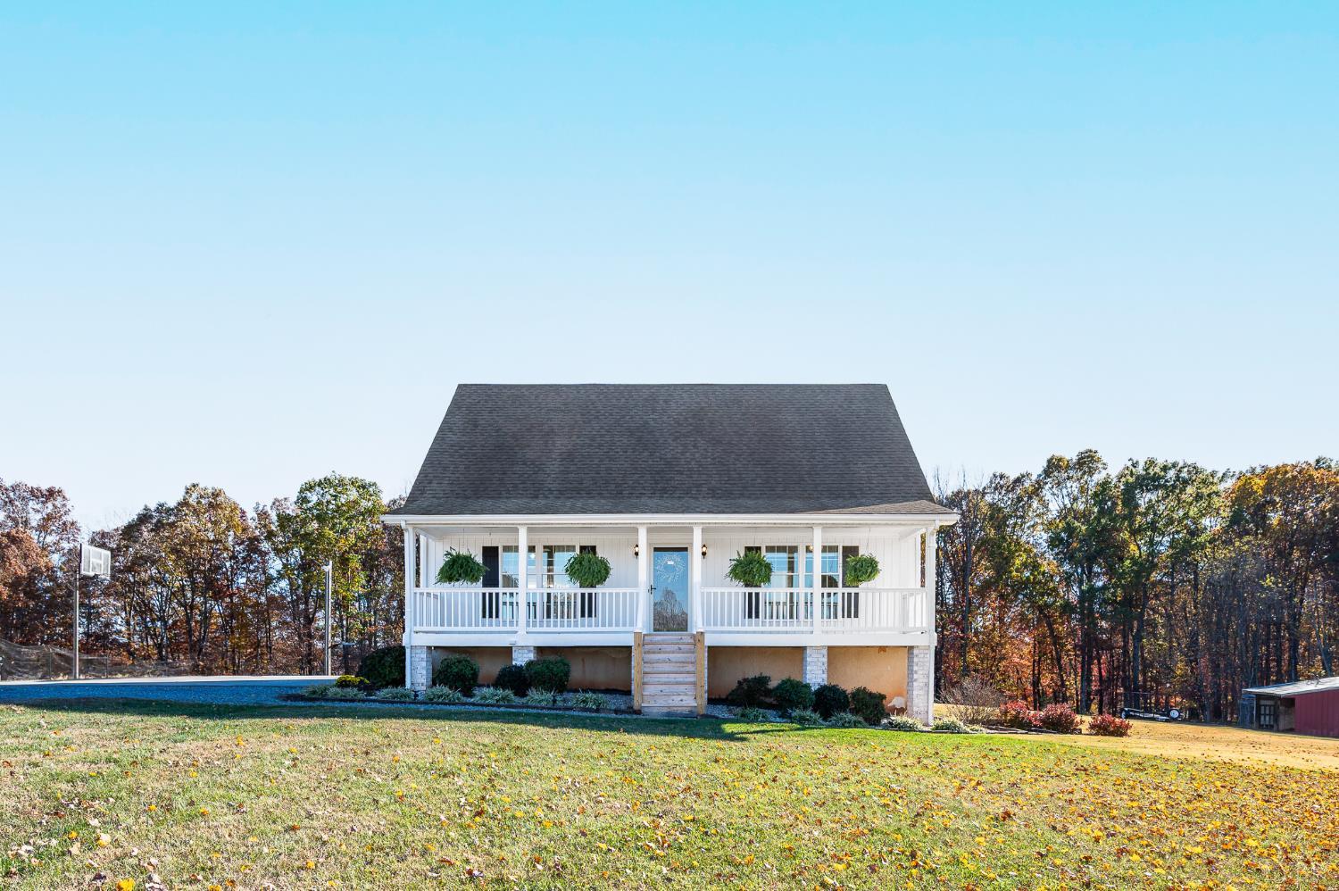 a front view of house with yard and trees in the background