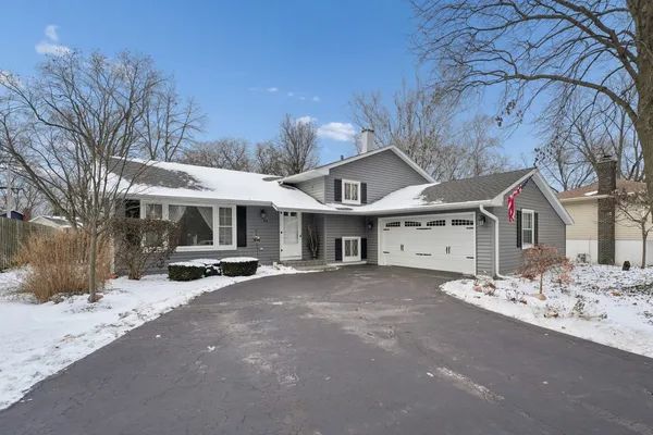 a view of a house with a yard covered in snow