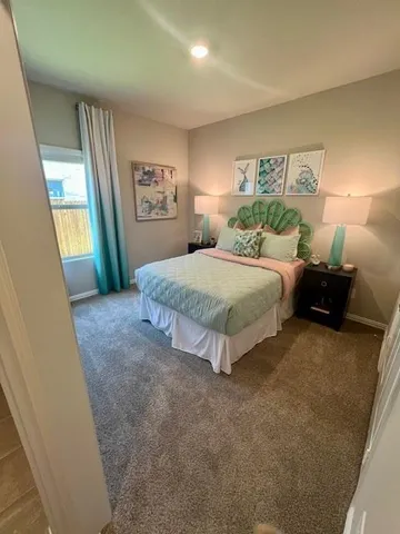 a spacious bedroom with a bed and a large mirror on the dresser