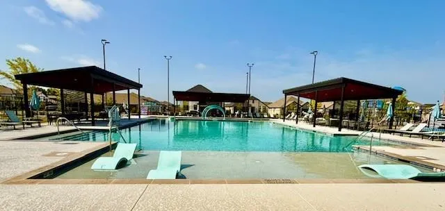 a patio with water view fountain and a fire pit