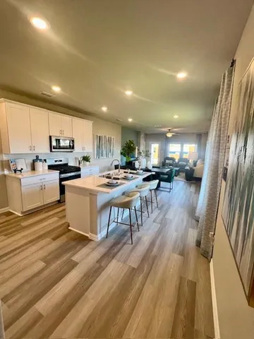 a kitchen with stainless steel appliances kitchen island granite countertop a stove a sink a refrigerator and cabinets