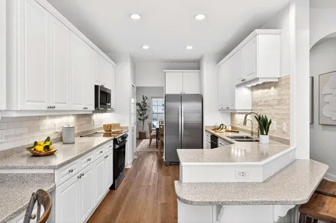 a kitchen with stainless steel appliances granite countertop a sink a stove and refrigerator