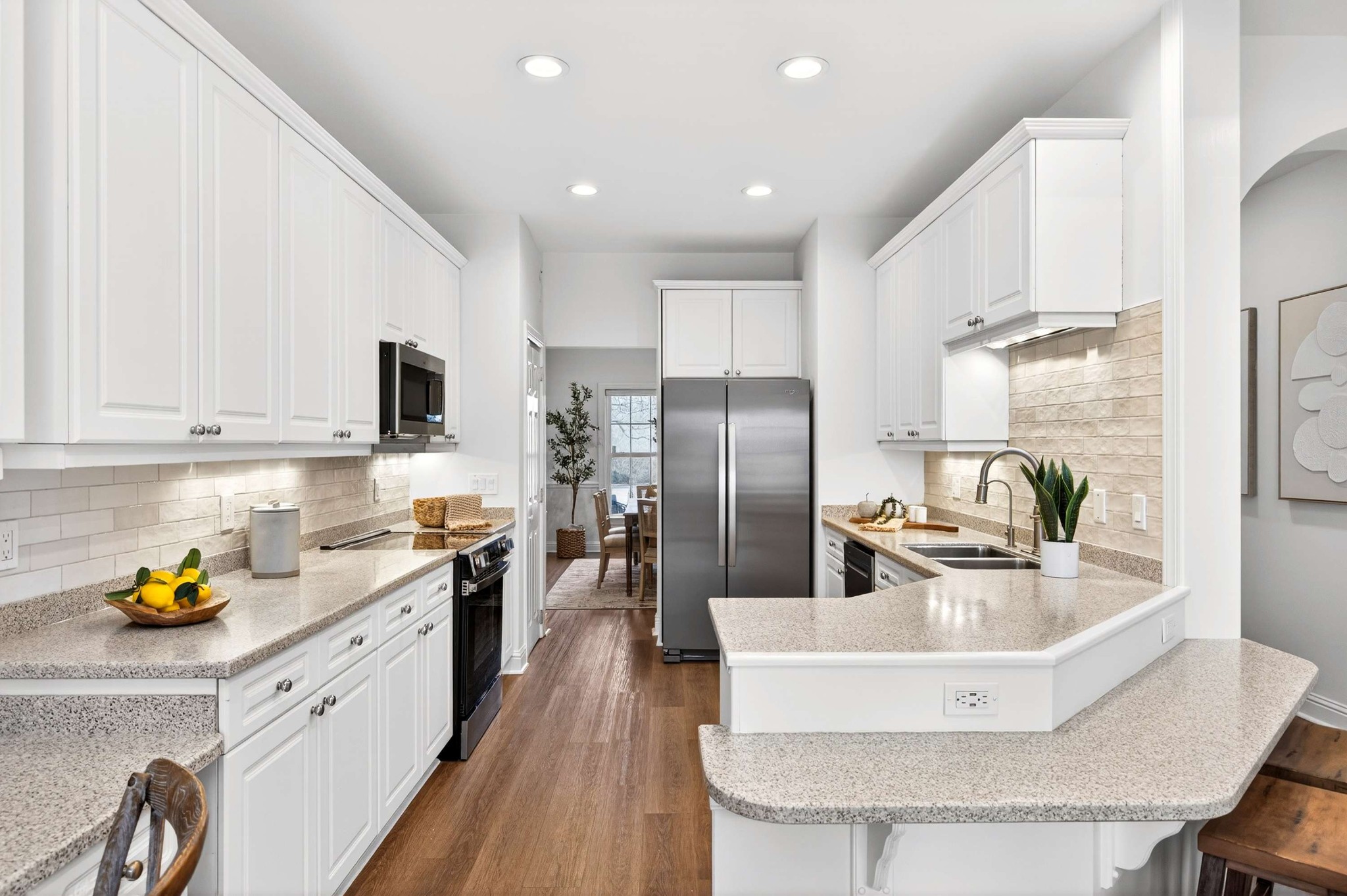 a kitchen with stainless steel appliances granite countertop a sink a stove and refrigerator