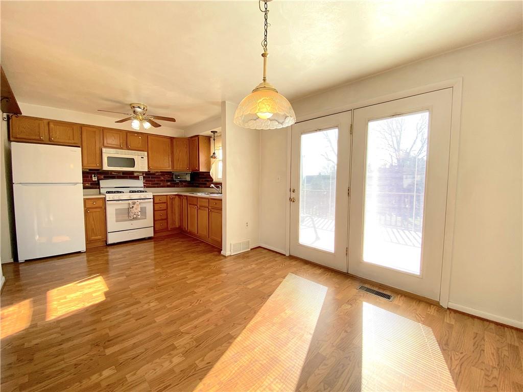1821 Cowling Road Scottdale, PA 15683 - Photo 11 of 24 a view of a kitchen with a stove wooden cabinets and a refrigerator