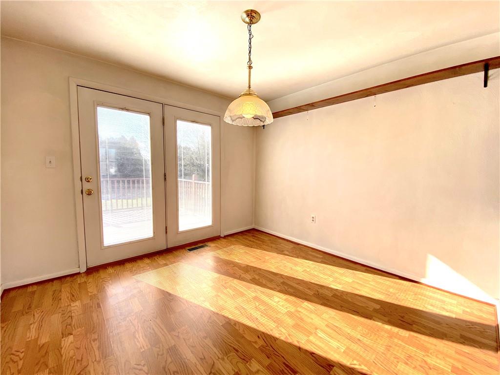 1821 Cowling Road Scottdale, PA 15683 - Photo 12 of 24 a view of an empty room with wooden floor and a window