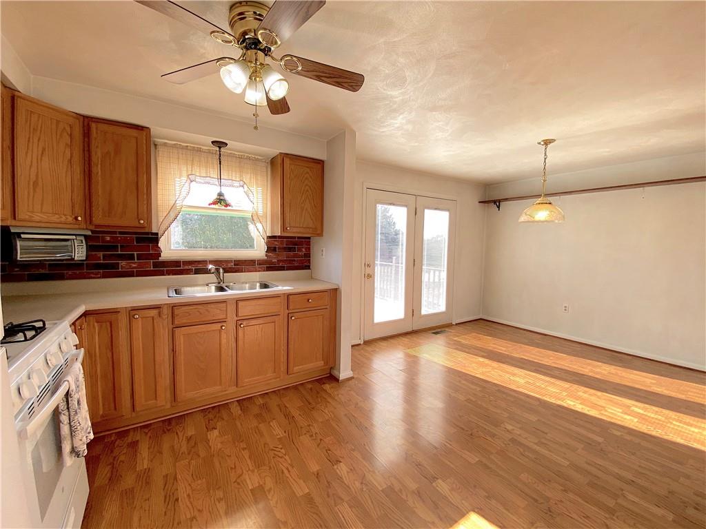 1821 Cowling Road Scottdale, PA 15683 - Photo 8 of 24 a kitchen with granite countertop a stove a sink and a window