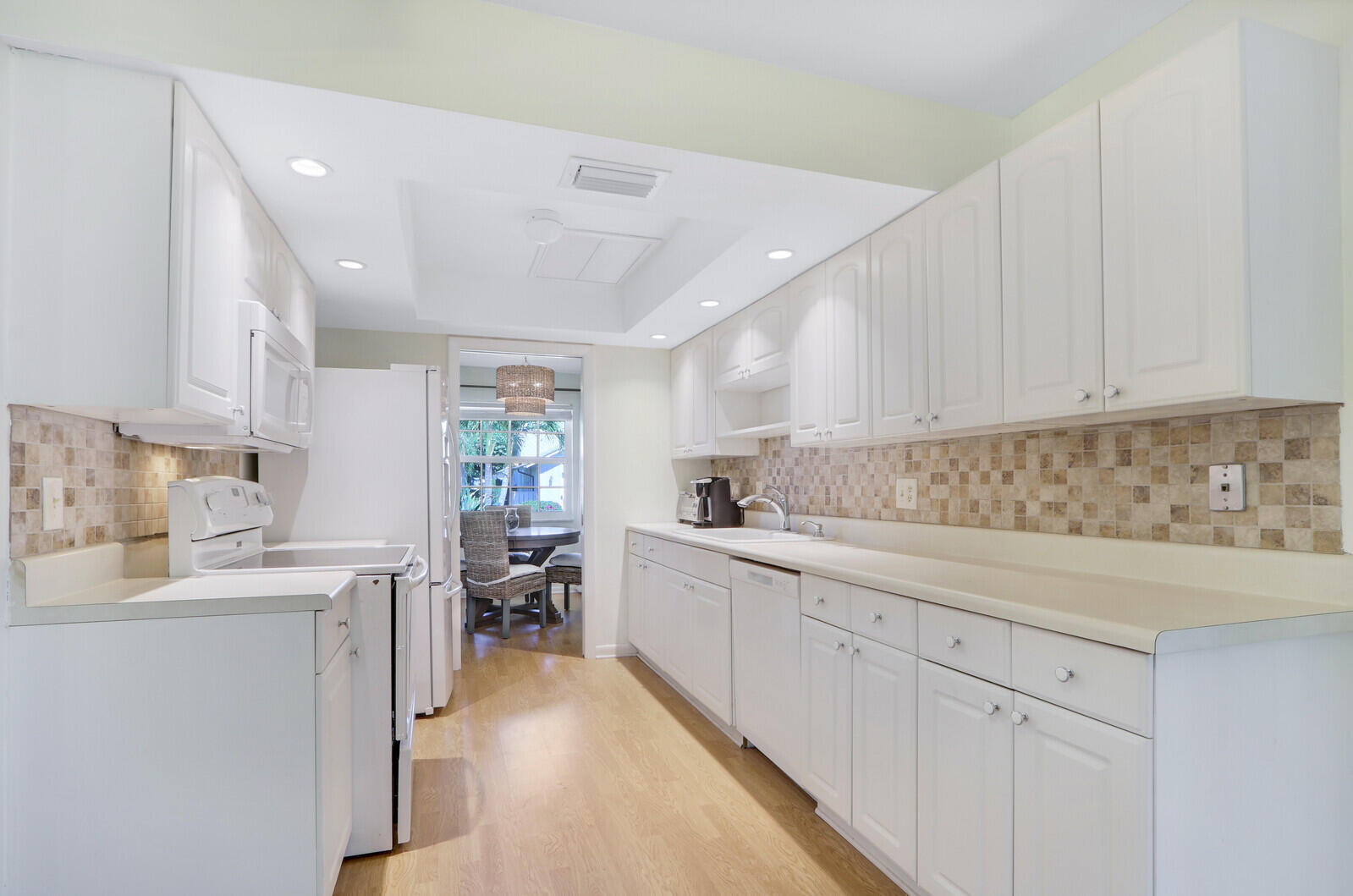 8574 Southeast Seagrape Way Hobe Sound, FL 33455 - Photo 14 of 38 a kitchen with a sink window and cabinets