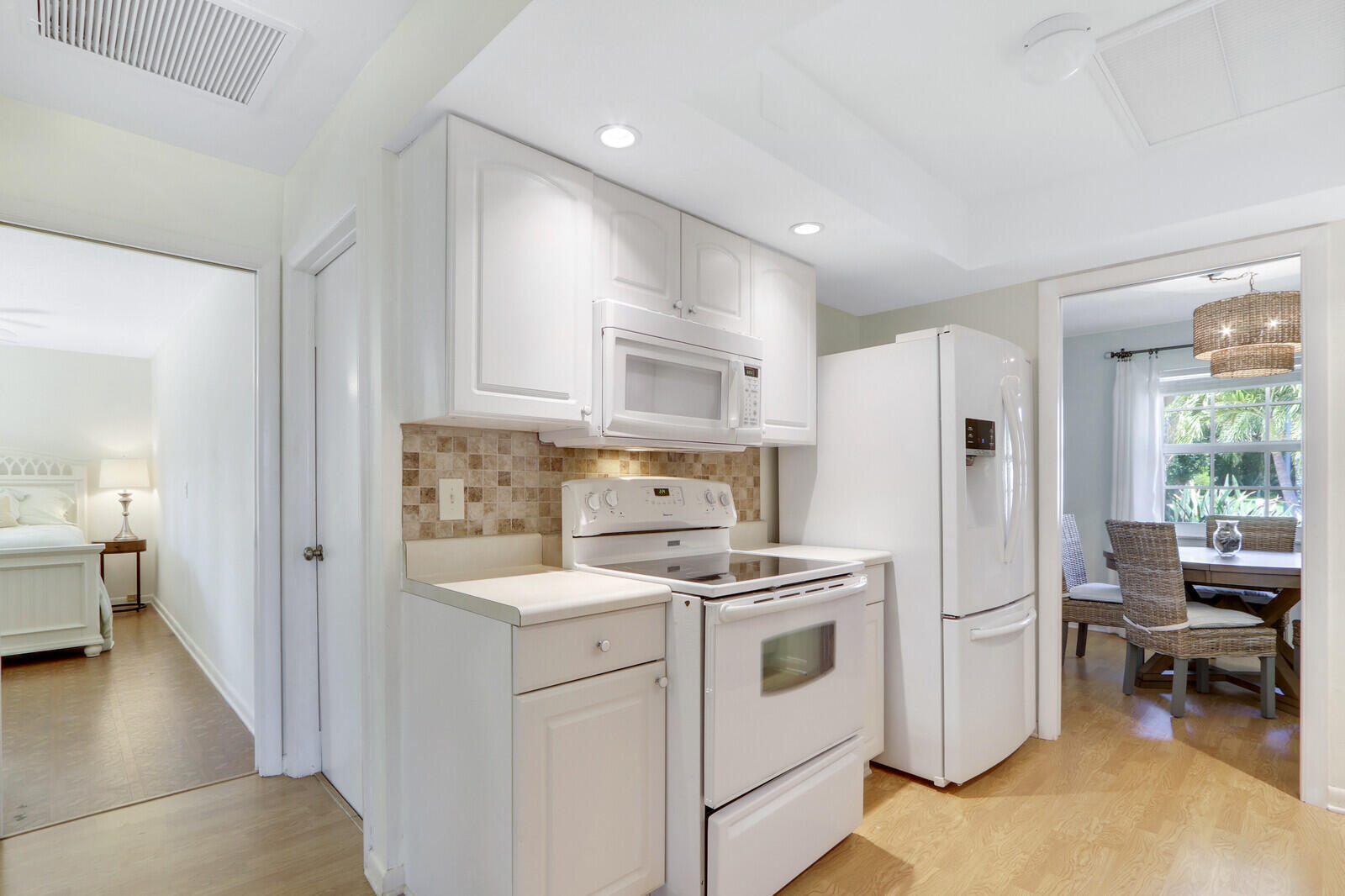 8574 Southeast Seagrape Way Hobe Sound, FL 33455 - Photo 15 of 38 a kitchen with a refrigerator a stove and a dining table