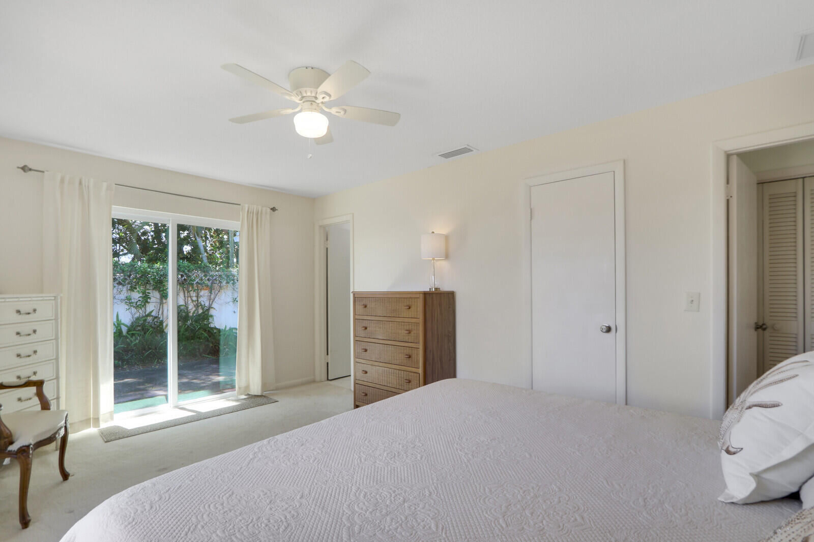 8574 Southeast Seagrape Way Hobe Sound, FL 33455 - Photo 26 of 38 a bedroom with a bed and a large window with outer view