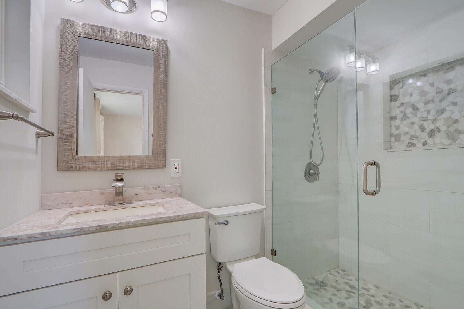 8574 Southeast Seagrape Way Hobe Sound, FL 33455 - Photo 27 of 38 a bathroom with a granite countertop sink toilet a mirror and shower