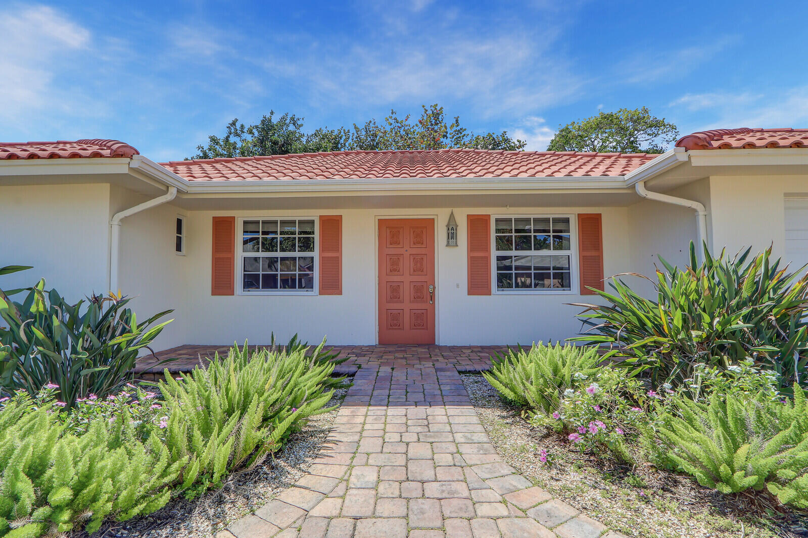 8574 Southeast Seagrape Way Hobe Sound, FL 33455 - Photo 5 of 38 a front view of a house with a garden