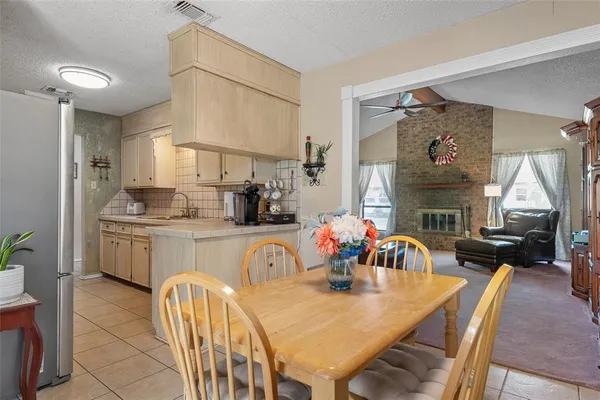 a kitchen with stainless steel appliances granite countertop a kitchen island a table and chairs in it