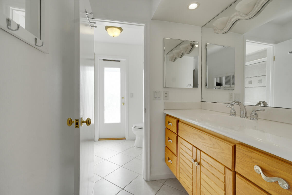 19842 Wilkinson Leas Road Jupiter, FL 33469 - Photo 50 of 75 a bathroom with a granite countertop sink a mirror and a