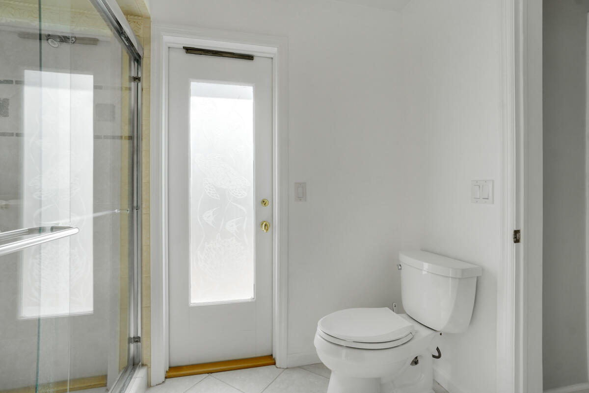 19842 Wilkinson Leas Road Jupiter, FL 33469 - Photo 51 of 75 a white toilet sitting next to a bathroom sink