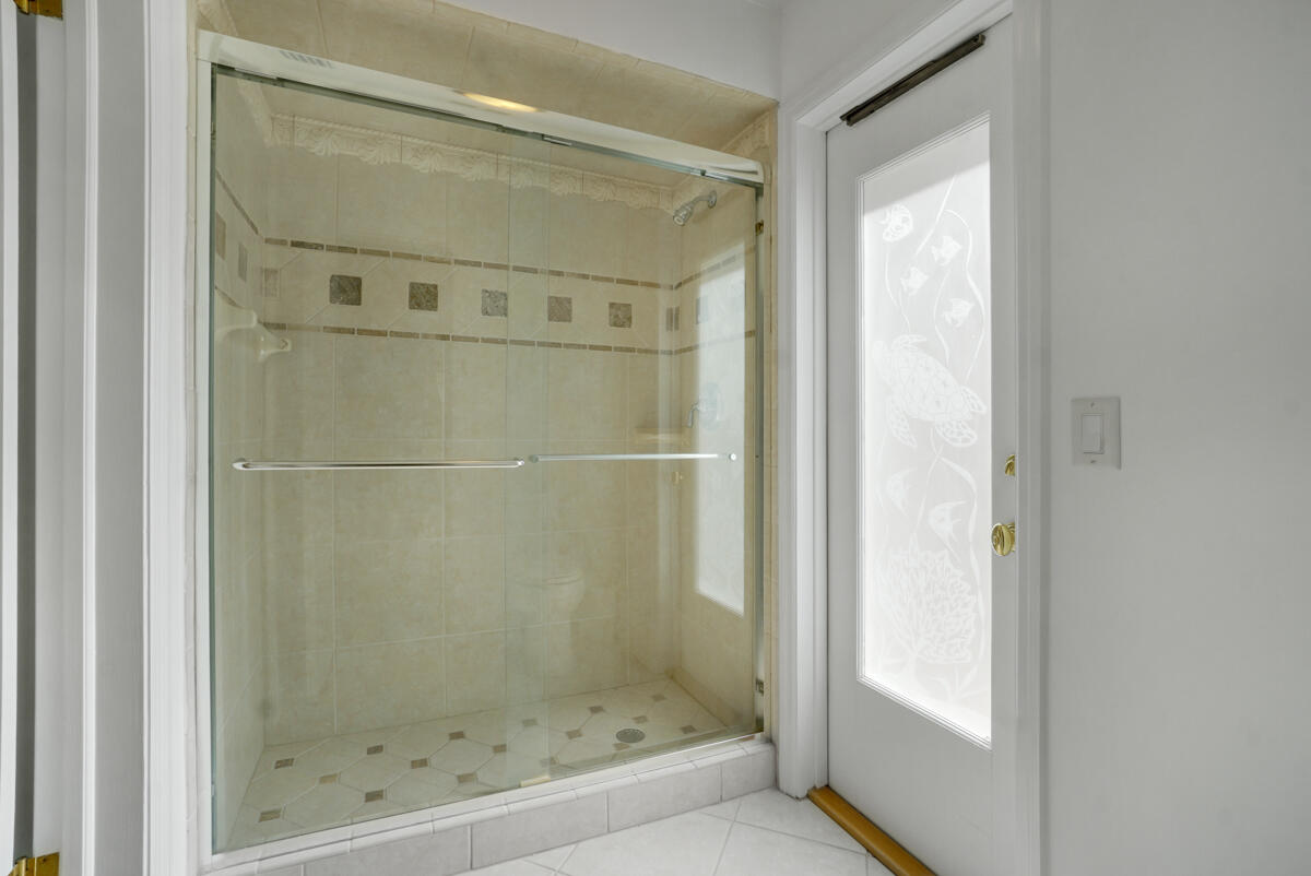 19842 Wilkinson Leas Road Jupiter, FL 33469 - Photo 52 of 75 a bathroom with a glass shower door