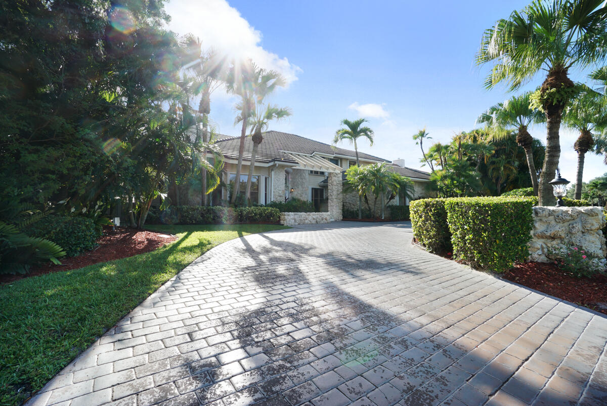 19842 Wilkinson Leas Road Jupiter, FL 33469 - Photo 9 of 75 a front view of a house with a yard and potted plants